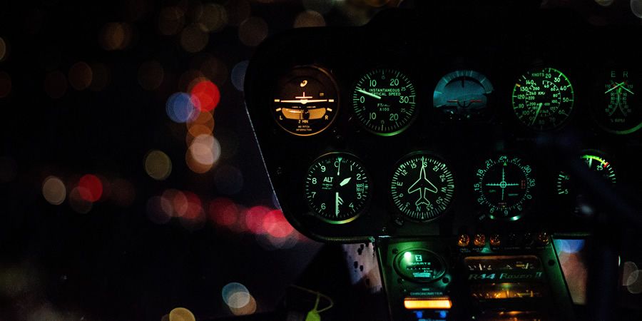 A glowing control panel dashboard inside an aircraft cockpit at night